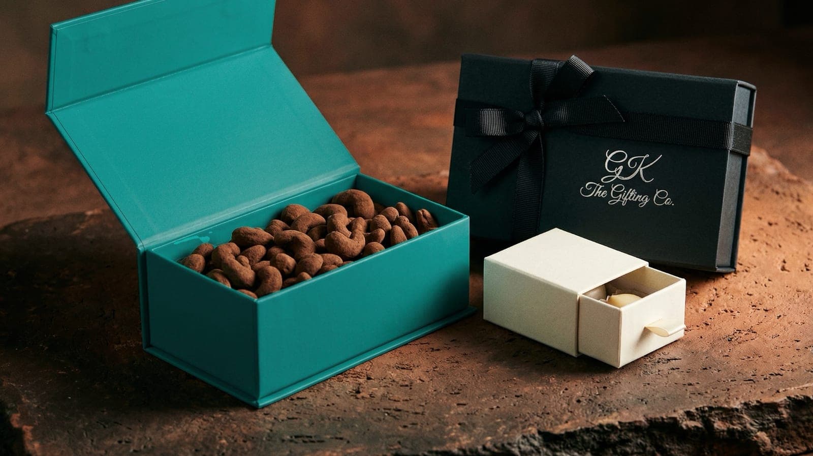 Custom branded gift box duo in teal, black, and ivory packaging
